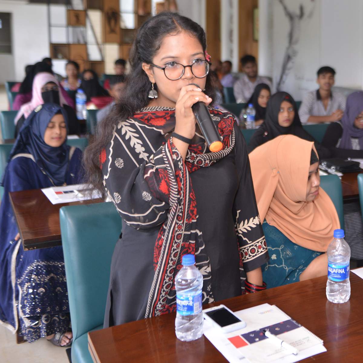 A youth talking in a meeting with microphone