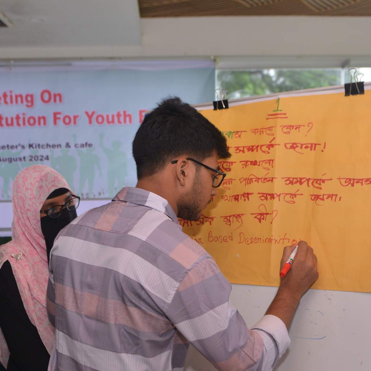 Image - A youth is writing on a poster